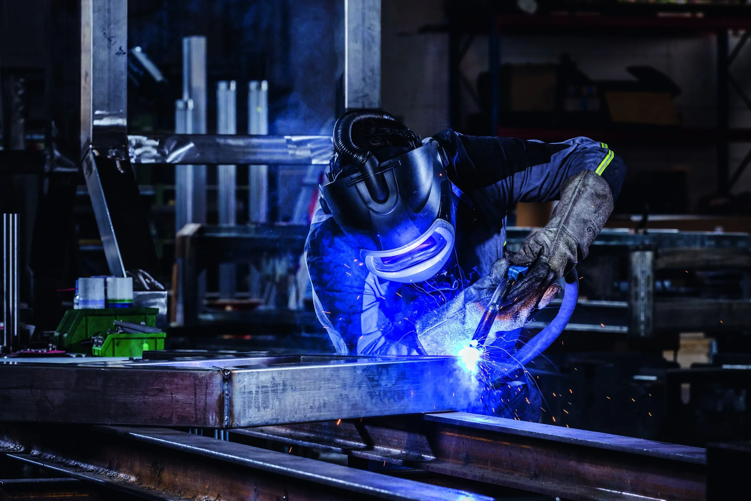 Schweißer bei der Arbeit mit Funkenflug in der Werkstatt